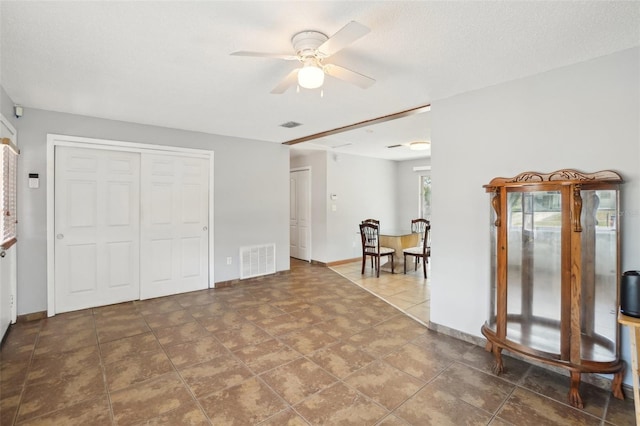 interior space with a ceiling fan, visible vents, and baseboards