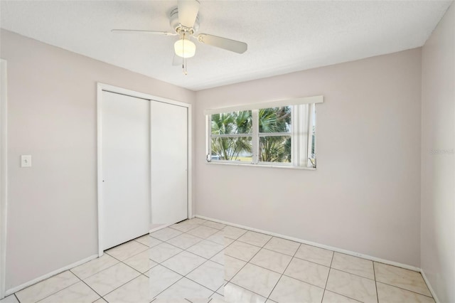 unfurnished bedroom featuring a ceiling fan, a closet, and baseboards