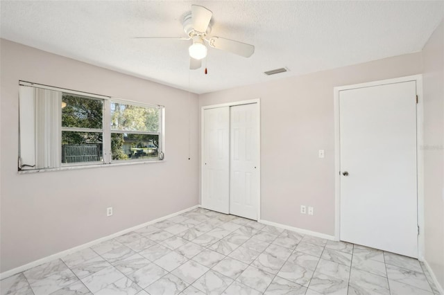 unfurnished bedroom with marble finish floor, baseboards, visible vents, and a closet