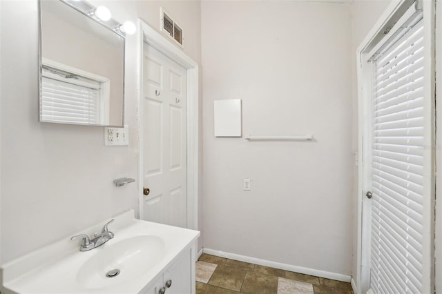 bathroom with vanity, visible vents, and baseboards