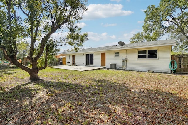 back of house featuring cooling unit, a patio area, fence, and a lawn