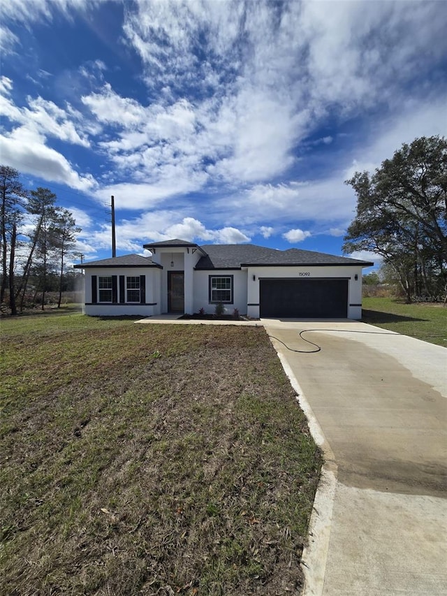 view of front of property featuring driveway, an attached garage, a front lawn, and stucco siding