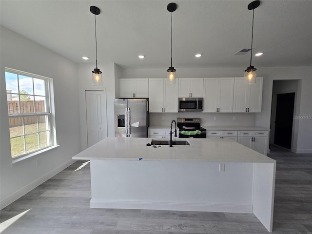 kitchen featuring appliances with stainless steel finishes, visible vents, a sink, and white cabinetry