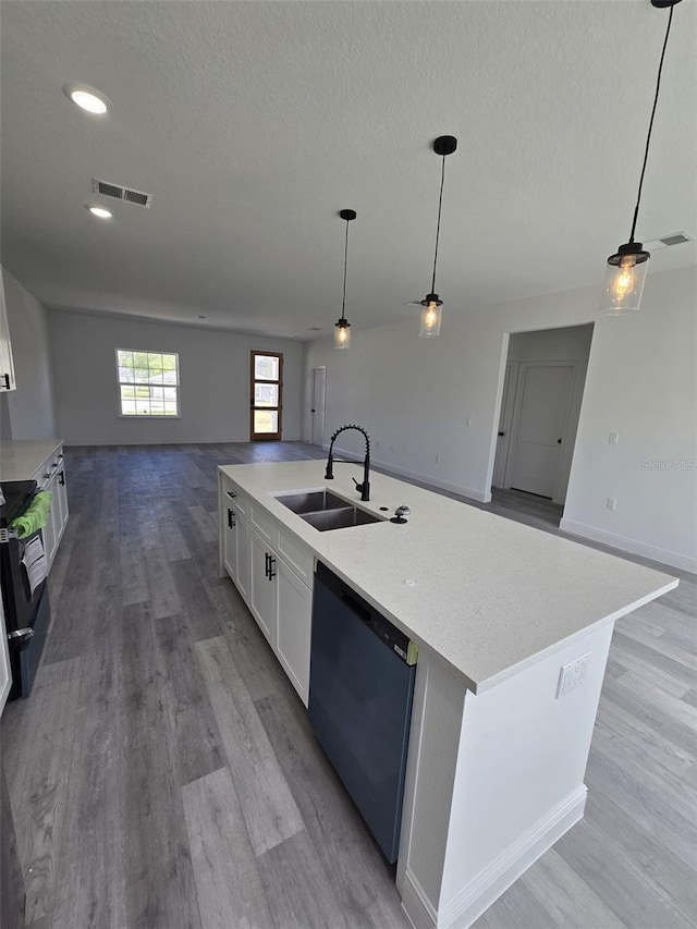 kitchen featuring visible vents, open floor plan, white cabinets, a sink, and dishwasher