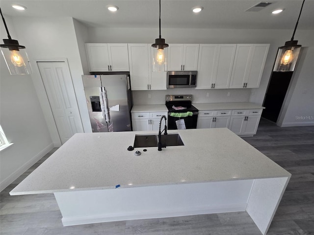 kitchen with visible vents, white cabinets, an island with sink, appliances with stainless steel finishes, and a sink