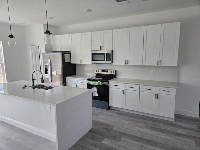 kitchen with stainless steel appliances, dark wood-style flooring, white cabinetry, and a sink