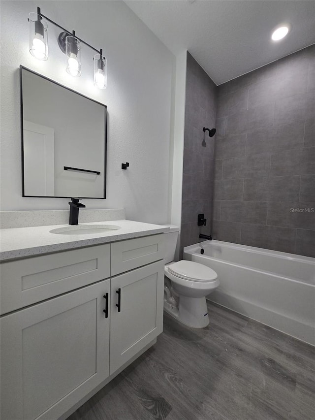 bathroom with vanity, tub / shower combination, wood finished floors, and toilet