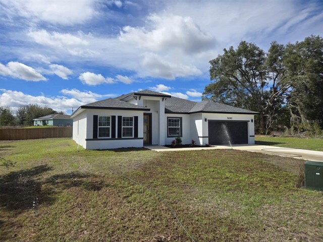 view of front of property featuring stucco siding, a front yard, fence, a garage, and driveway