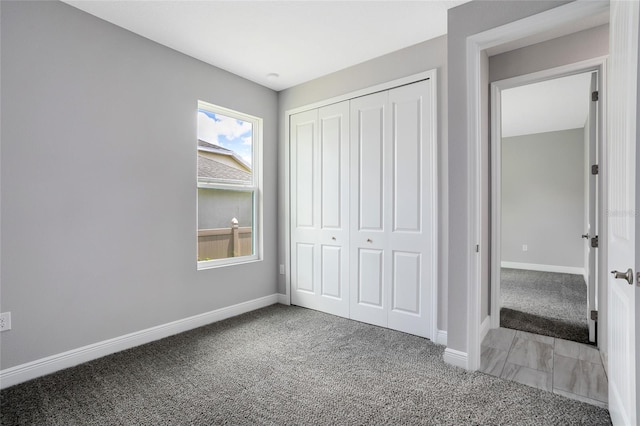 unfurnished bedroom with a closet, baseboards, and carpet floors