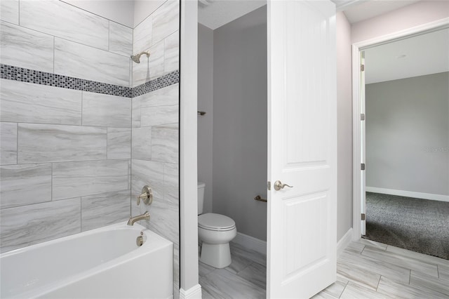 full bathroom featuring baseboards, toilet, and shower / tub combination