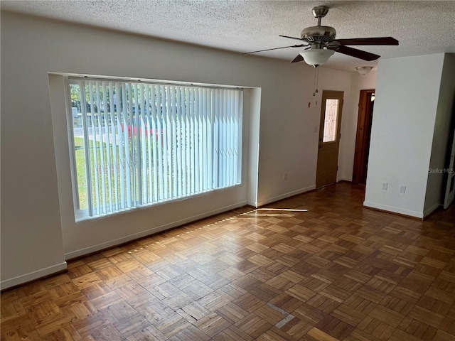 empty room with baseboards, a textured ceiling, and a ceiling fan