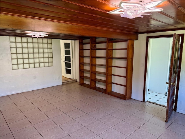unfurnished room with wood ceiling and light tile patterned flooring