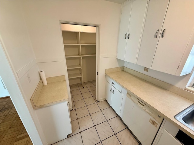 kitchen with white cabinets, white dishwasher, and light countertops