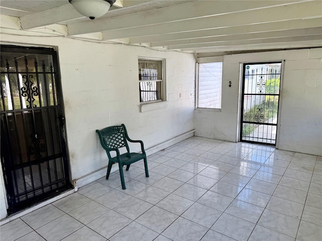 unfurnished sunroom with beam ceiling