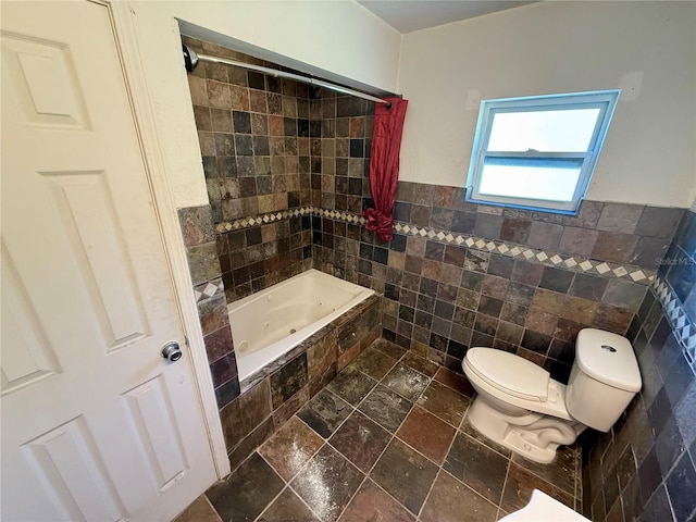 full bathroom featuring toilet, tile walls, and stone tile floors