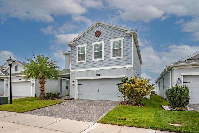 view of front facade with decorative driveway, a front yard, and stucco siding