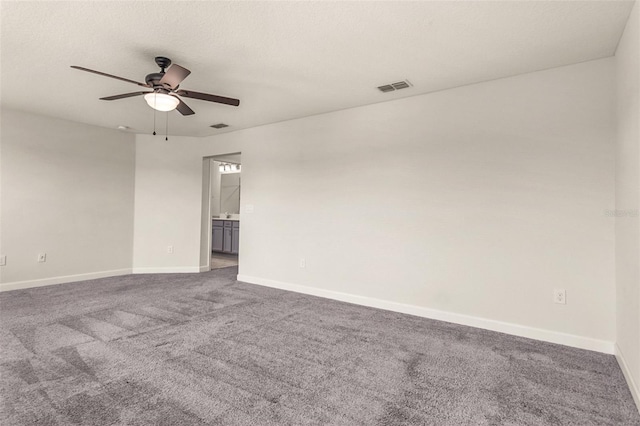 spare room featuring a textured ceiling, a ceiling fan, visible vents, baseboards, and carpet