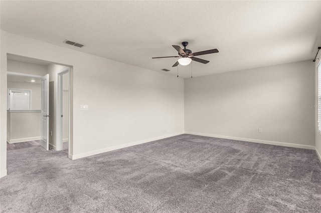 unfurnished room with ceiling fan, carpet flooring, visible vents, and baseboards