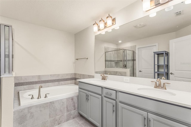 bathroom with double vanity, a stall shower, a sink, and a bath