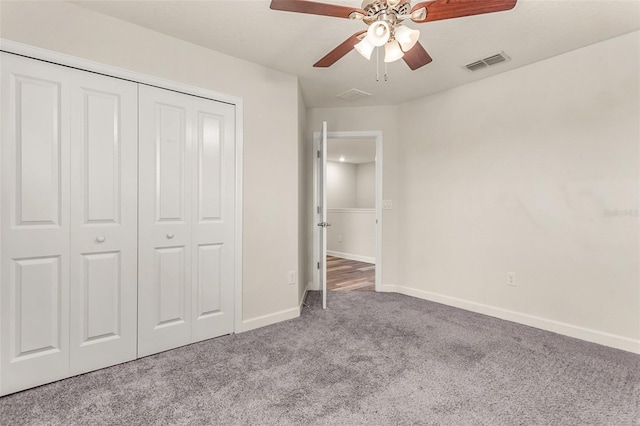 unfurnished bedroom featuring carpet, a closet, visible vents, ceiling fan, and baseboards