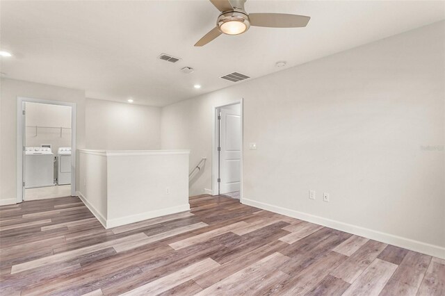 empty room featuring washing machine and clothes dryer, recessed lighting, visible vents, wood finished floors, and baseboards