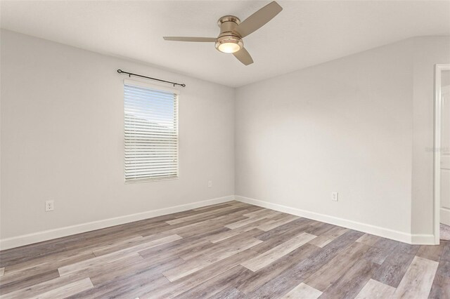 empty room featuring light wood-style floors, baseboards, and a ceiling fan