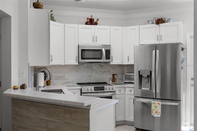 kitchen featuring white cabinetry, decorative backsplash, stainless steel appliances, and a sink