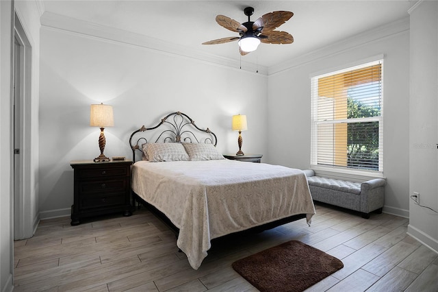 bedroom featuring light wood-type flooring, baseboards, ornamental molding, and a ceiling fan