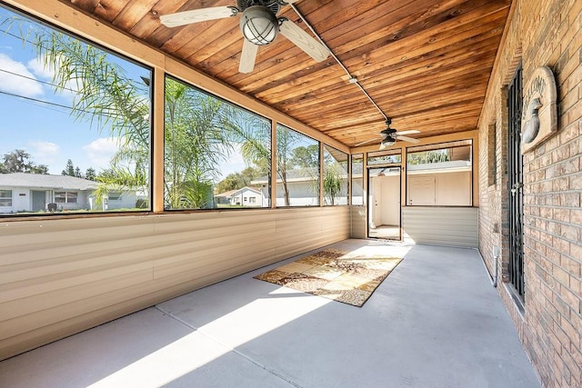 unfurnished sunroom with a ceiling fan and wood ceiling