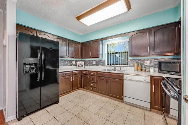 kitchen featuring black appliances, light countertops, backsplash, and a sink