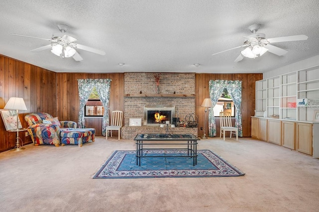 living area featuring a fireplace, plenty of natural light, carpet, and wood walls