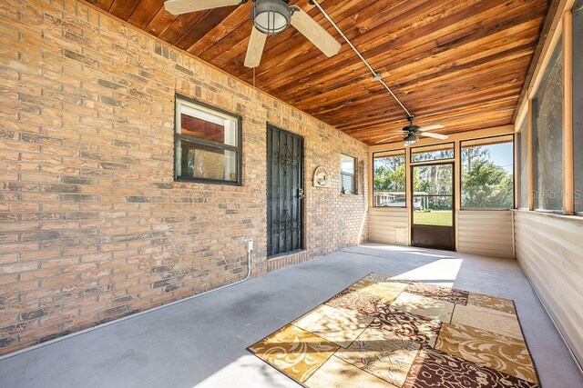 unfurnished sunroom with wooden ceiling and ceiling fan