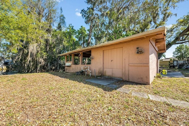 back of property with a yard and stucco siding