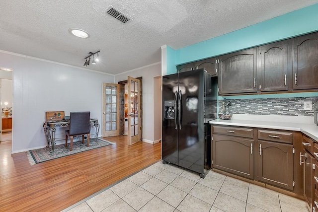 kitchen with light wood finished floors, light countertops, visible vents, crown molding, and black fridge with ice dispenser