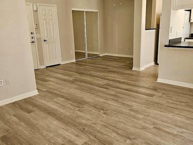 spare room with baseboards and wood finished floors