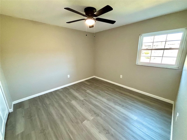 unfurnished room featuring dark wood-type flooring, baseboards, and a ceiling fan