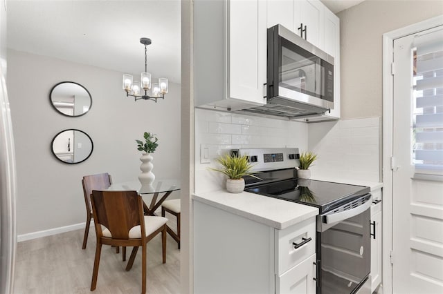1920 E Edgewood Dr Unit A5, Lakeland, FL 33803 - kitchen featuring stainless steel appliances, backsplash, light wood-style flooring, a chandelier, and light countertops