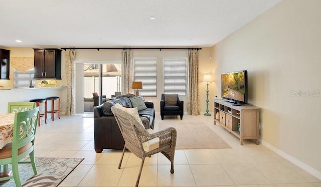 living area with light tile patterned floors and baseboards