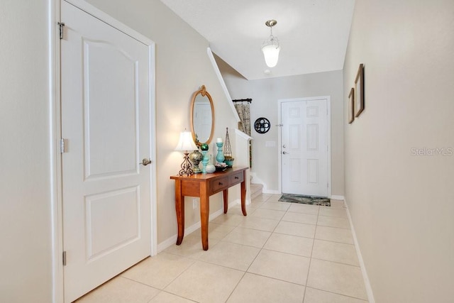 foyer featuring light tile patterned floors and baseboards