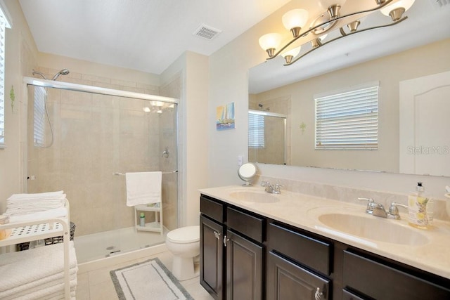 full bathroom featuring double vanity, visible vents, a shower stall, and a sink