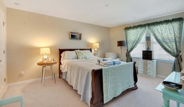 bedroom featuring light colored carpet and baseboards