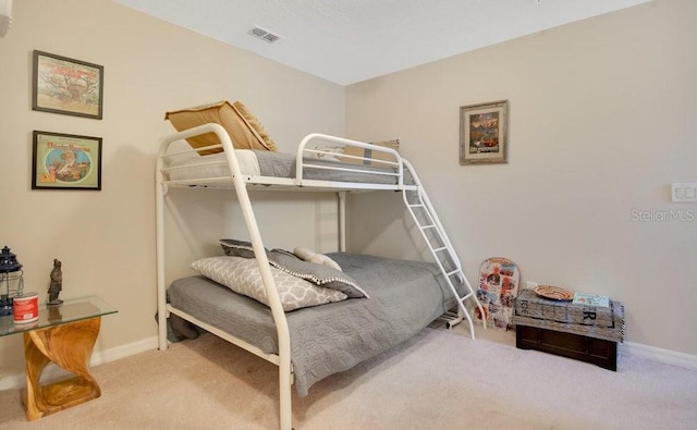 carpeted bedroom with visible vents and baseboards