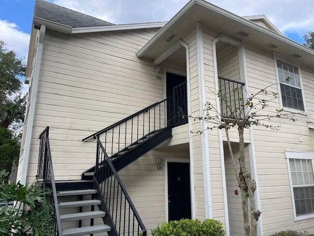 doorway to property featuring a shingled roof