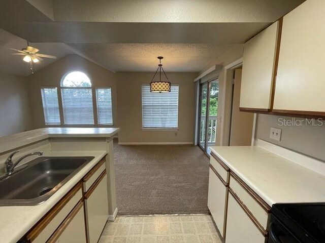 kitchen featuring light countertops, a sink, and white cabinetry