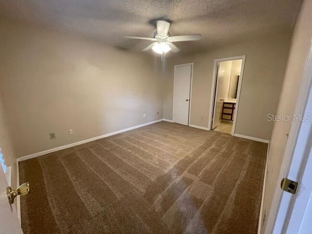 unfurnished bedroom with baseboards, a ceiling fan, connected bathroom, a textured ceiling, and carpet floors