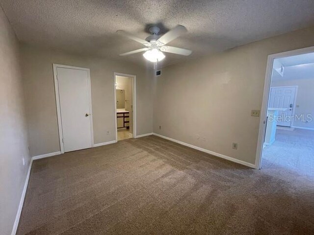 unfurnished bedroom with carpet floors, baseboards, and a textured ceiling