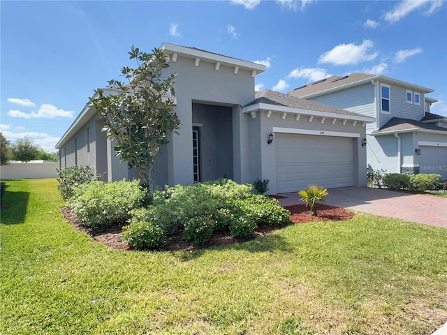 view of front facade with a garage, a front lawn, driveway, and stucco siding