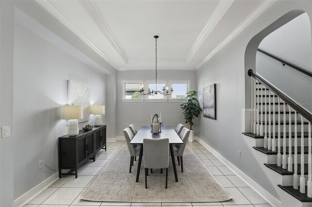 dining space with stairway, ornamental molding, a raised ceiling, and light tile patterned flooring