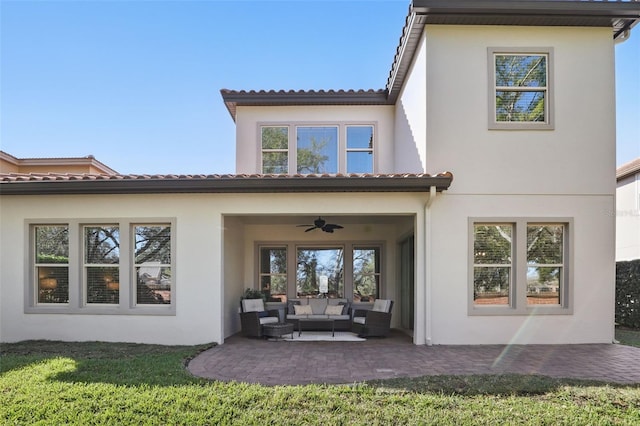 back of house with stucco siding, outdoor lounge area, a ceiling fan, and a patio