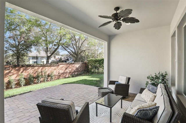 view of patio featuring fence, outdoor lounge area, and a ceiling fan